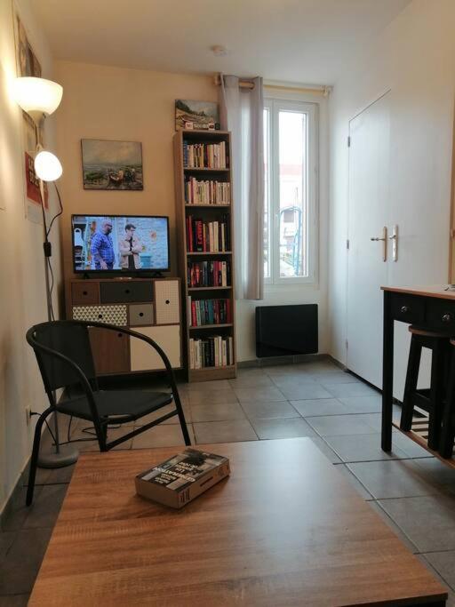 un salon avec une chaise et une télévision dans l'établissement S1 Logement entier tout équipé Courtenay, à Courtenay