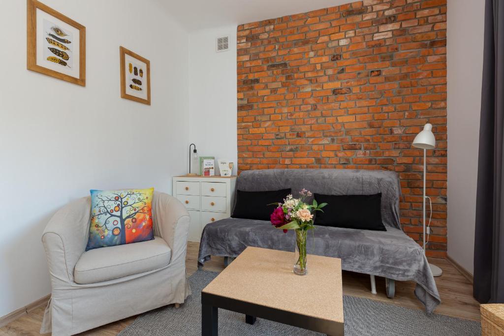 ein Wohnzimmer mit 2 Sofas und einer Ziegelwand in der Unterkunft Apartment Bialobrzeska Warsaw by Renters in Warschau