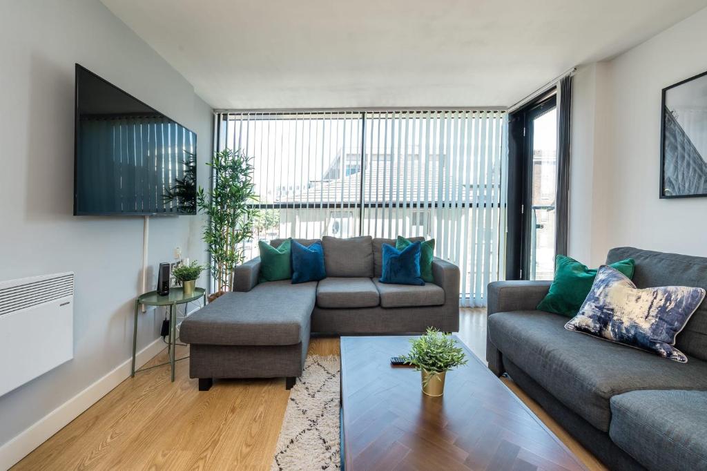 a living room with two couches and a table at Host & Stay - The Pall Mall Balcony Apt in Liverpool