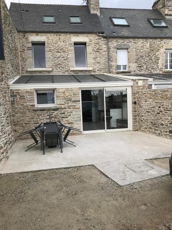 un patio con una mesa frente a un edificio en 3 rue Barthélémy en Cherbourg en Cotentin