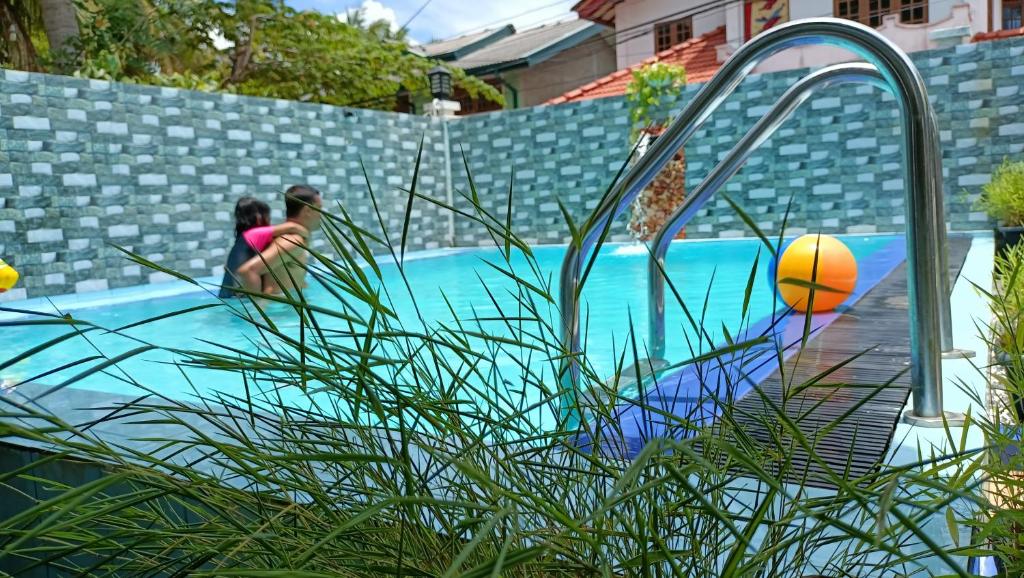 Due donne che giocano con una palla in piscina di Andorra Tourist Resort Anuradhapura a Anuradhapura