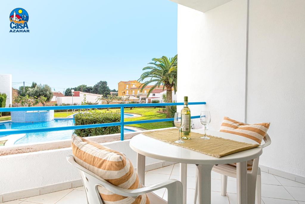 a balcony with a table and two glasses of wine at Apartamentos Nova Romana Casa Azahar in Alcossebre