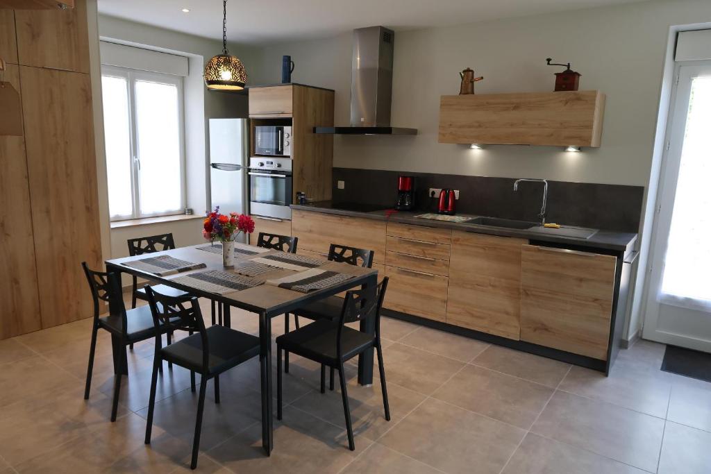 eine Küche mit einem Tisch und Stühlen im Zimmer in der Unterkunft Le Sophora in Chéu