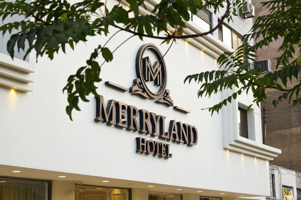 安曼的住宿－New MerryLand Hotel，麦金兰房子的一侧的标志