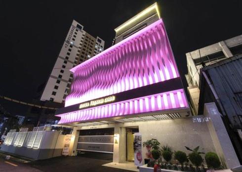 un bâtiment avec une façade violette éclairée la nuit dans l'établissement Hotel French Code, à Busan