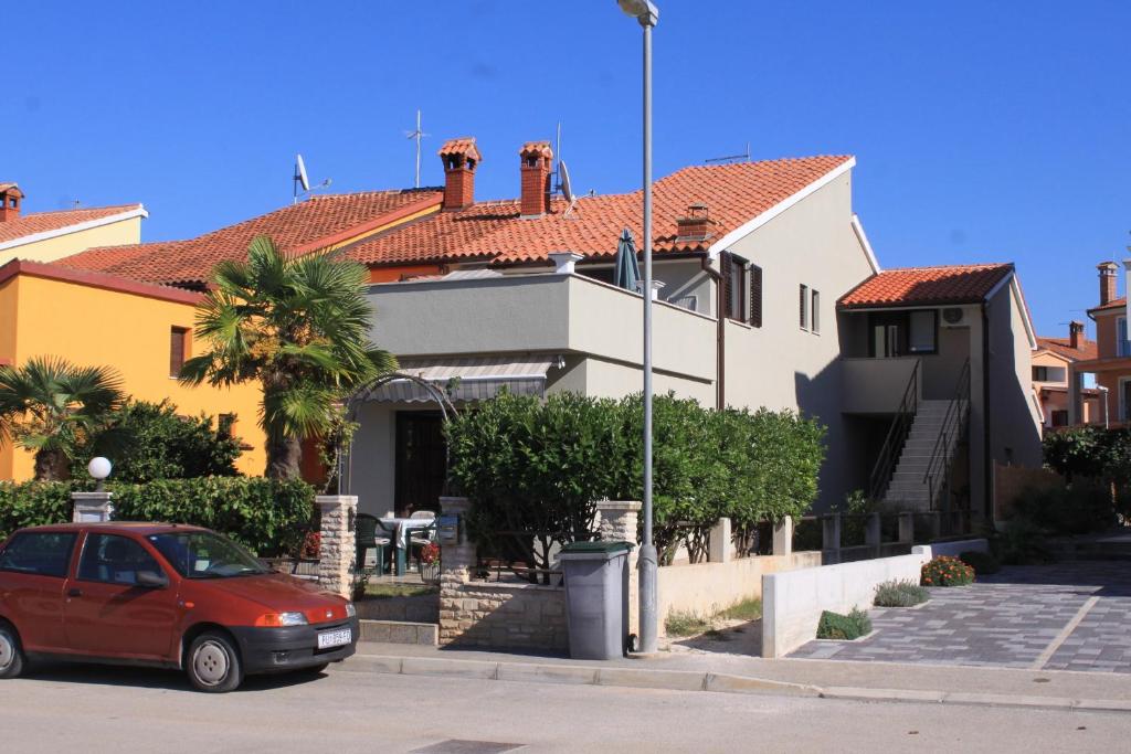 een rode auto geparkeerd voor een huis bij Apartments with a parking space Fazana - 7205 in Fažana