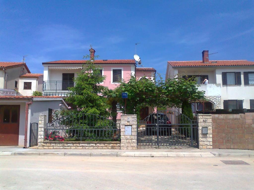 una casa rosa con una valla delante en Apartments with a parking space Fazana - 7281 en Fažana