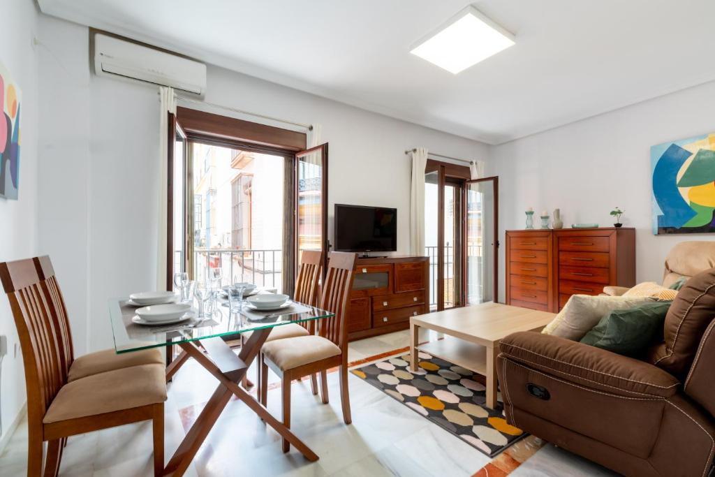 salon ze stołem i kanapą w obiekcie Holi-Rent Cuna w Sewilli