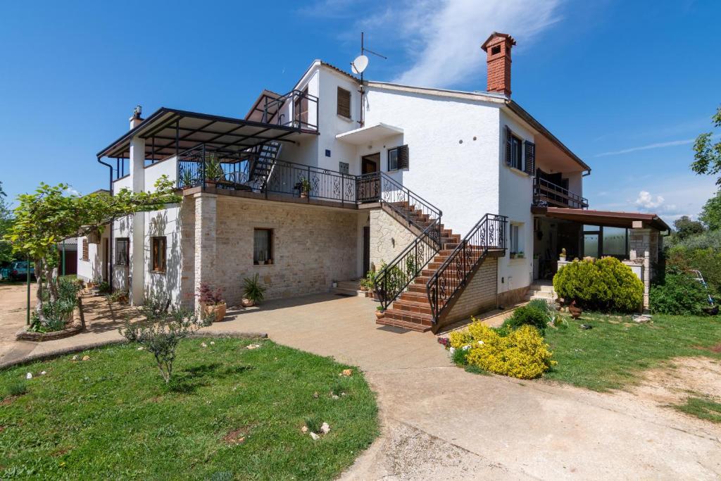 una vista exterior de una casa con una escalera en Family friendly apartments with a swimming pool Sisan, Medulin - 7243, en Šišan