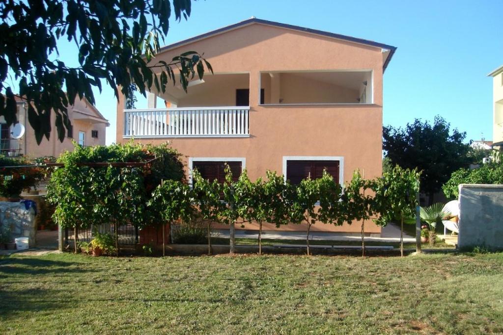 a pink house with a tree in front of it at Apartment Peroj 7254b in Vodnjan