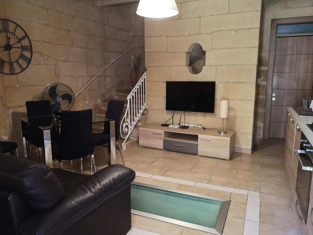 a living room with a couch and a television at Two gate town house in Senglea