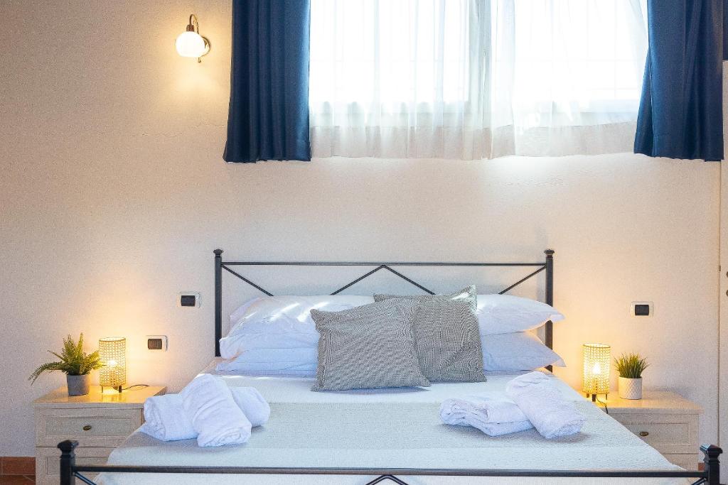 Una cama con almohadas blancas y toallas. en Palazzo Ghibellina 2 by Rental in Florence, en Florencia