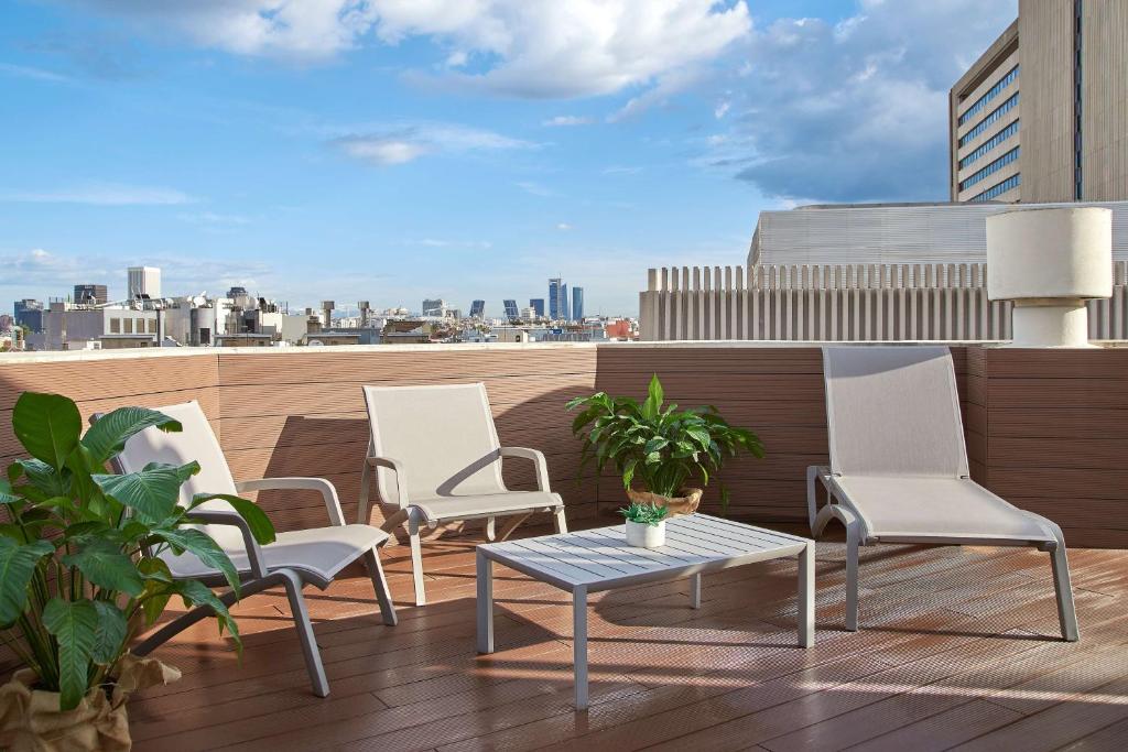 a group of chairs and a table on a rooftop at NH Madrid Balboa in Madrid