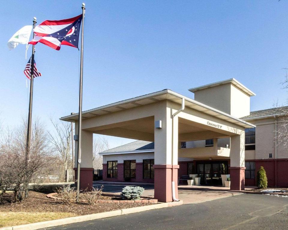 two flags flying in front of a building at Quality Inn & Suites Oakwood Village - Cleveland South in Oakwood