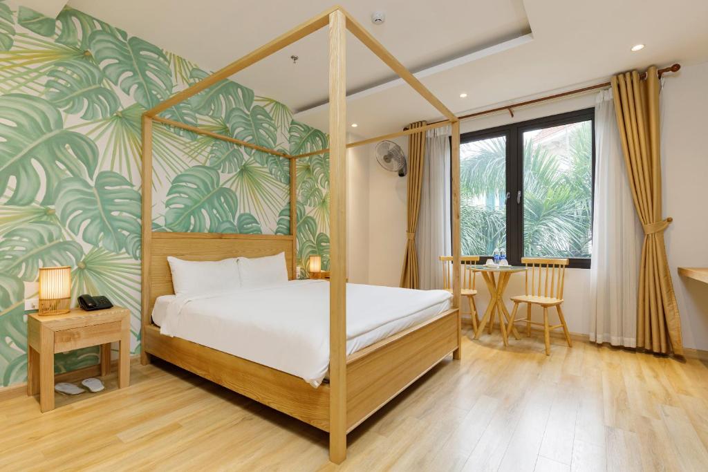 a bedroom with a canopy bed with a tropical wallpaper at Super OYO Capital O 1169 Le Grand Hanoi Hotel - The Charm in Hanoi