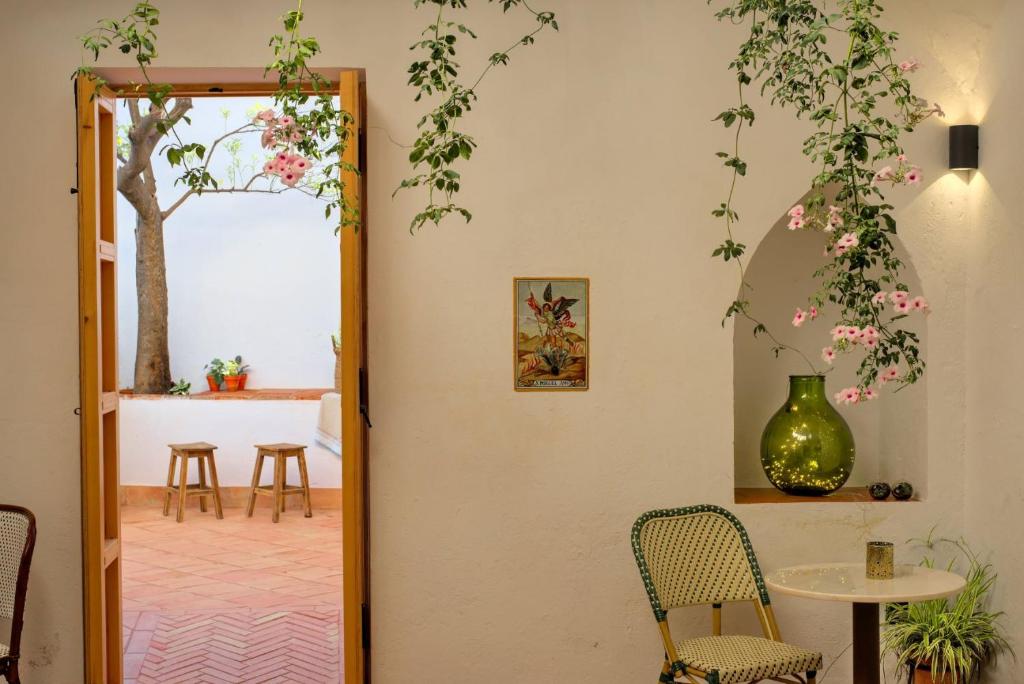 une porte menant à une chambre avec une table et des chaises. dans l'établissement Hotel Casa Ernestina, à Zafra