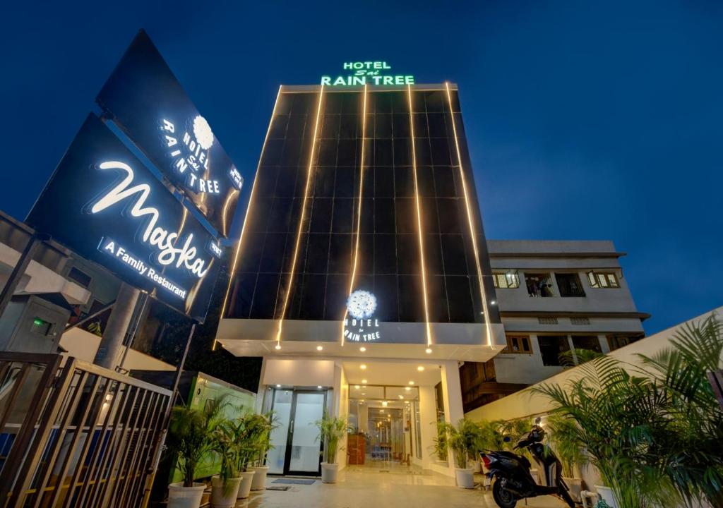 un grand bâtiment avec un panneau devant lui dans l'établissement Hotel Sai Rain Tree, à Guwahati