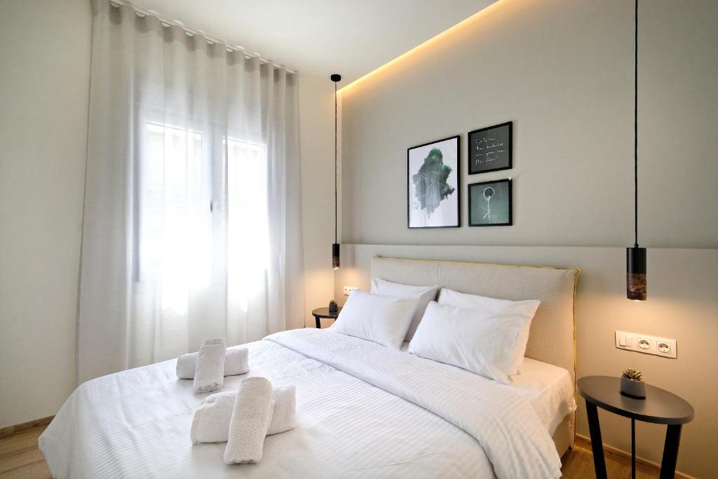 1 dormitorio con 1 cama blanca y 2 toallas en Eos Residence, en Atenas