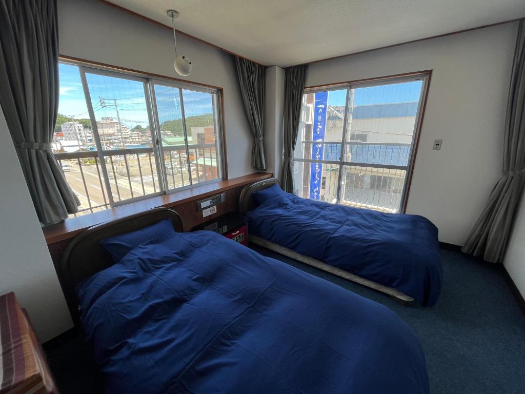 duas camas num quarto com vista para a cidade em MAGURO BLDG チェックインはWhyKumano em Nachikatsuura