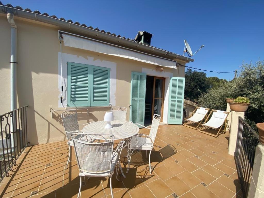a patio with a table and chairs and a cat on the roof at Ses Alzines Apartamento integrado en Casa Rural Habitada in Llucmajor
