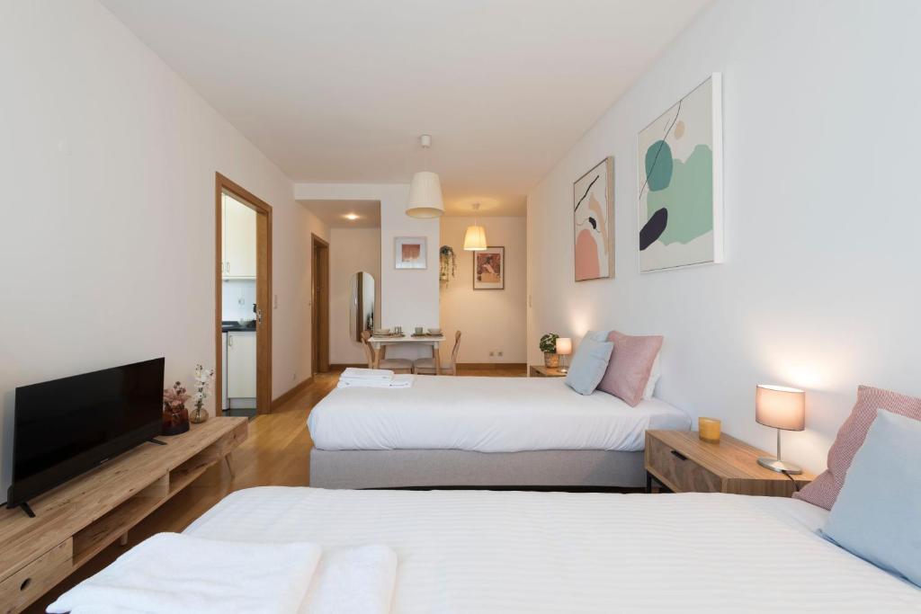 1 Schlafzimmer mit 2 Betten und einem Flachbild-TV in der Unterkunft Boavista Boho Apartment w/ Garage in Porto