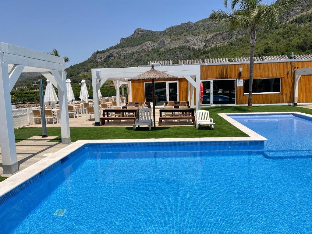 a pool with a gazebo and a table and chairs at Camping la escalada in Gandía