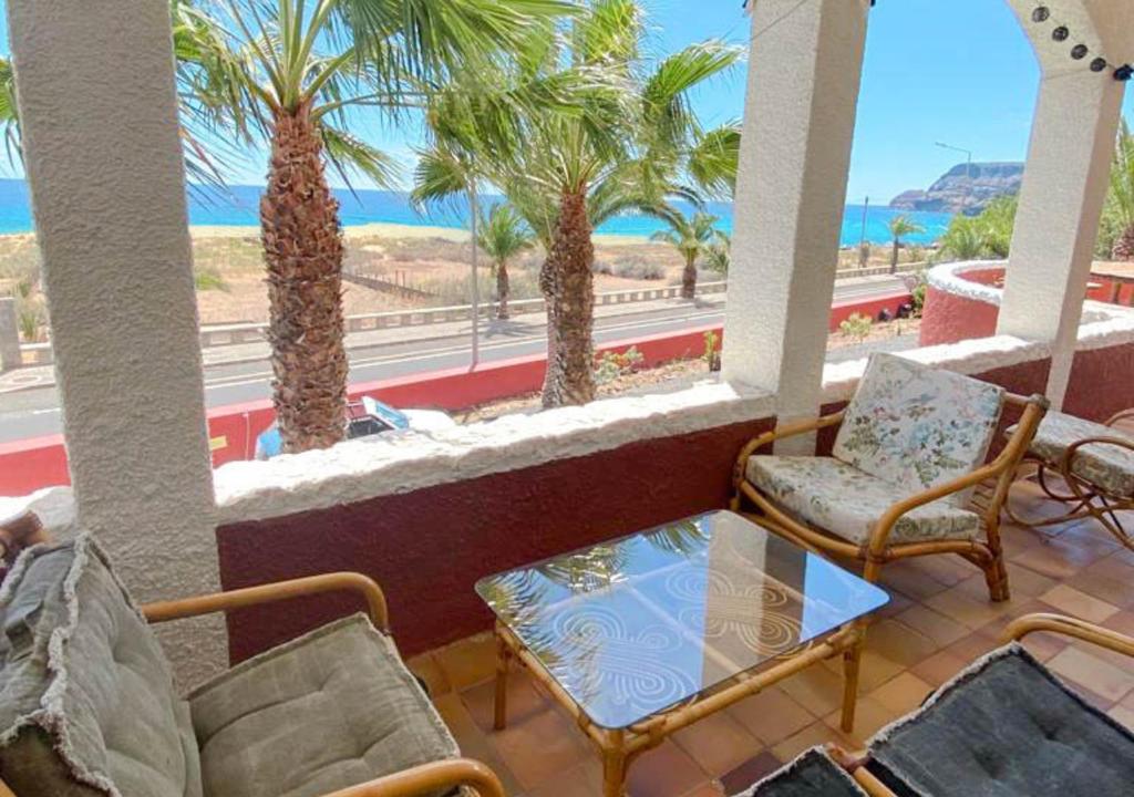 einen Balkon mit Stühlen, einem Tisch und Palmen in der Unterkunft Porto Santo Destination in Porto Santo