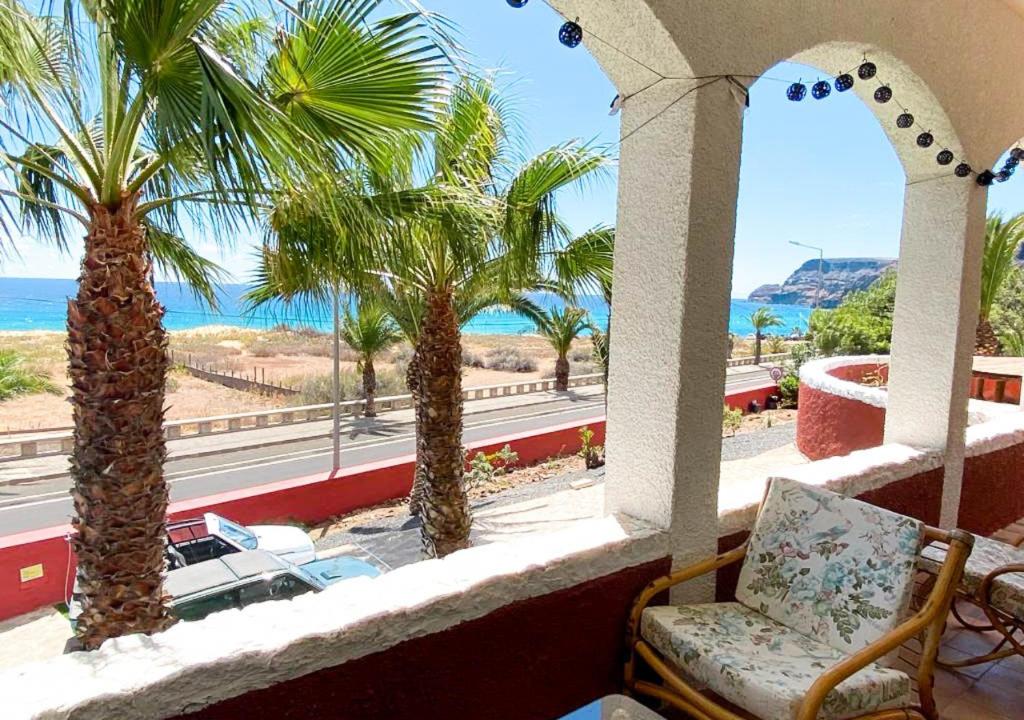 a balcony with palm trees and a view of the ocean at Porto Santo Destination in Porto Santo