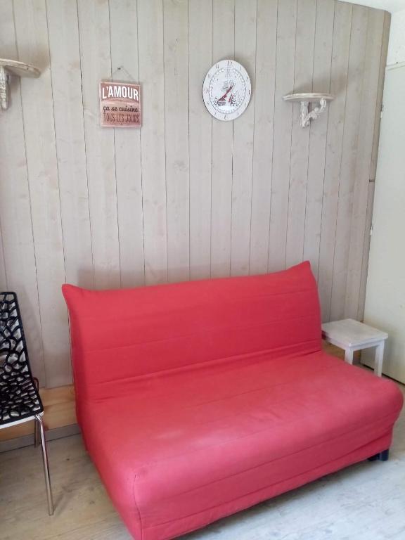 - un canapé rouge dans une pièce avec un panneau mural dans l'établissement Appartement risoul, 1 pièce , 4 personnes, à Risoul