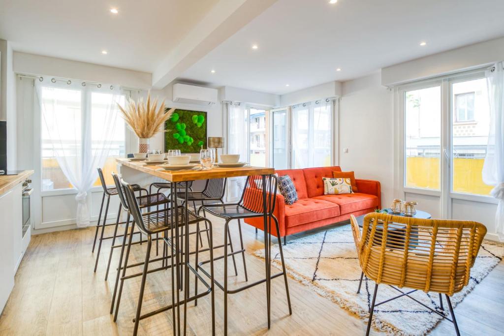 una cucina e un soggiorno con divano rosso di Appartement Wilsonia - Welkeys a Antibes