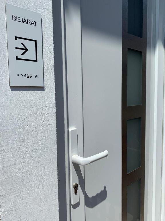 a sign on a door that says be patient at Attila Vendégház in Kiskunmajsa