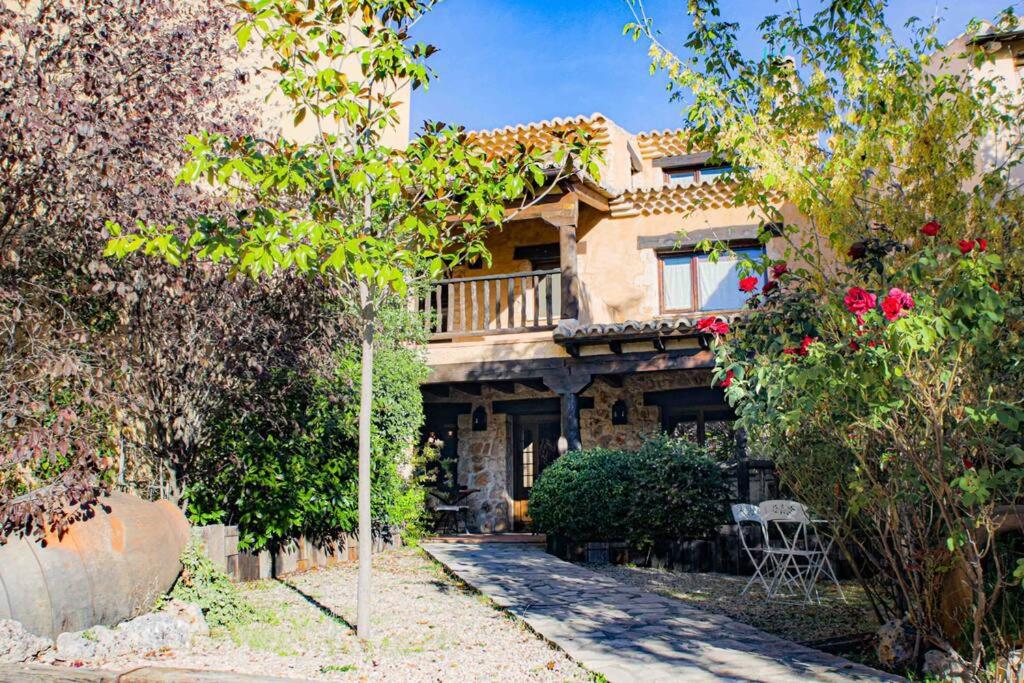 a house with a balcony in the middle of trees at Casa Rural LA LAVANDA Lugar de ensueño en la Alcarria in El Olivar