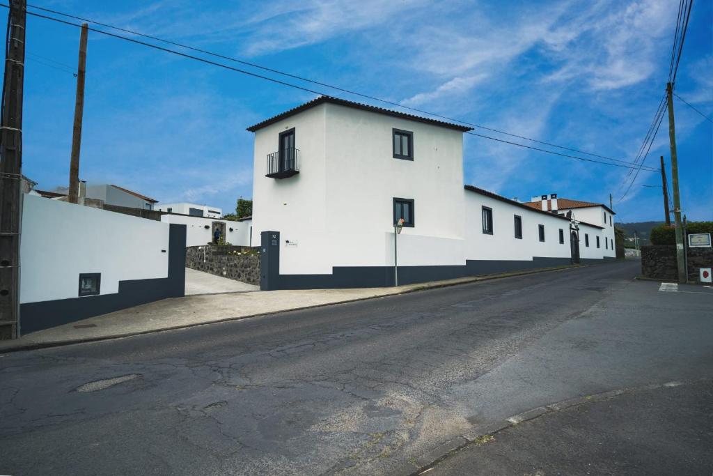 un edificio bianco sul lato di una strada di Vila Rosario a Ponta Delgada