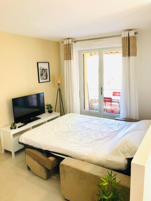 une chambre avec un grand lit et une télévision dans l'établissement Un coin de paradis 2 ou 4 personnes refait à neuf, à Sainte-Maxime