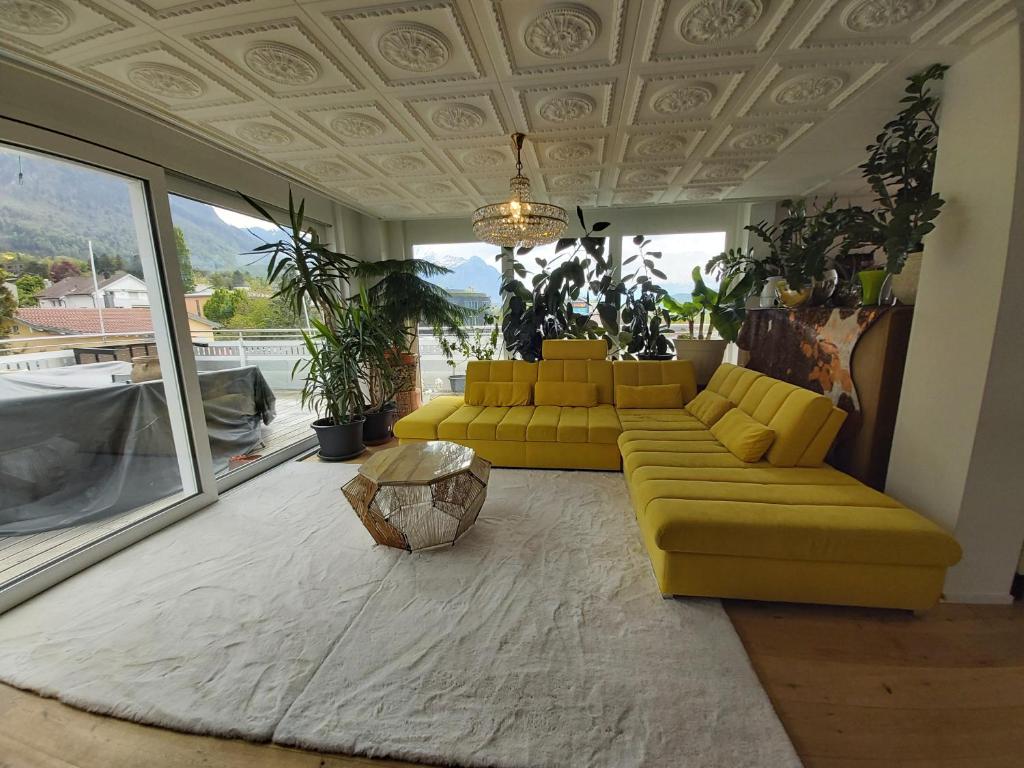 sala de estar con sofá amarillo y mesa en Penthouse with beautiful 360 terrace en Schaan