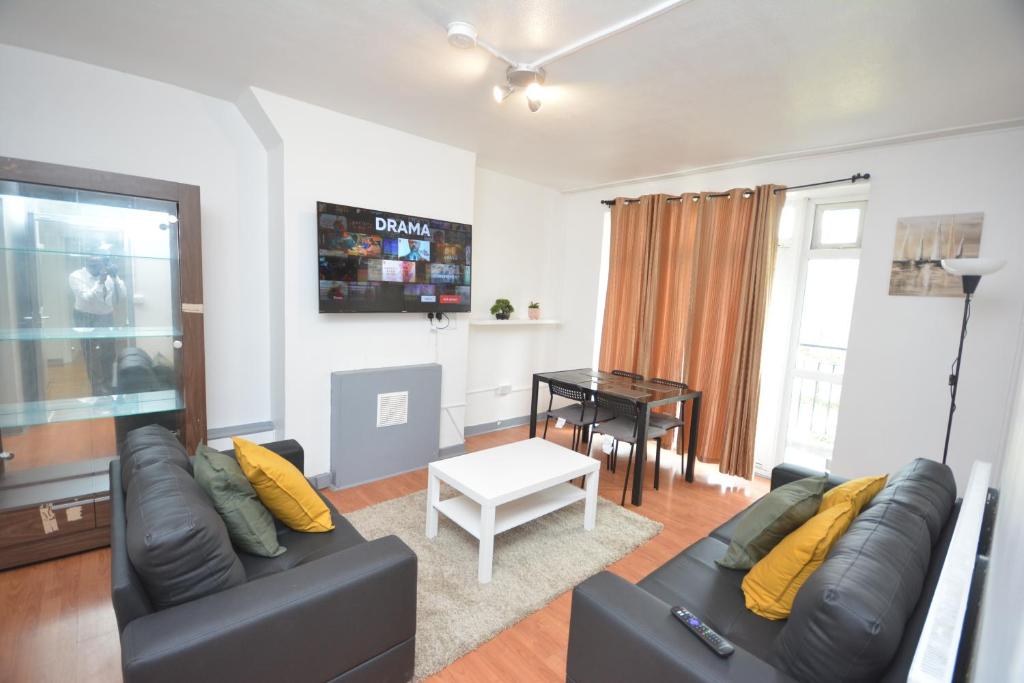 uma sala de estar com um sofá e uma mesa em Beautiful London 2 Bedroom Flat near Finsbury Park em Londres