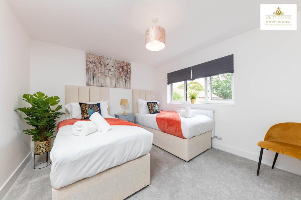 a bedroom with two beds and a chair at 3Bed 2Bath House Contractors Accommodation free Parking WiFi Stevenage Hertfordshire Self Catering Sleeps 6 Guests By White Orchid Property Relocation in Stevenage