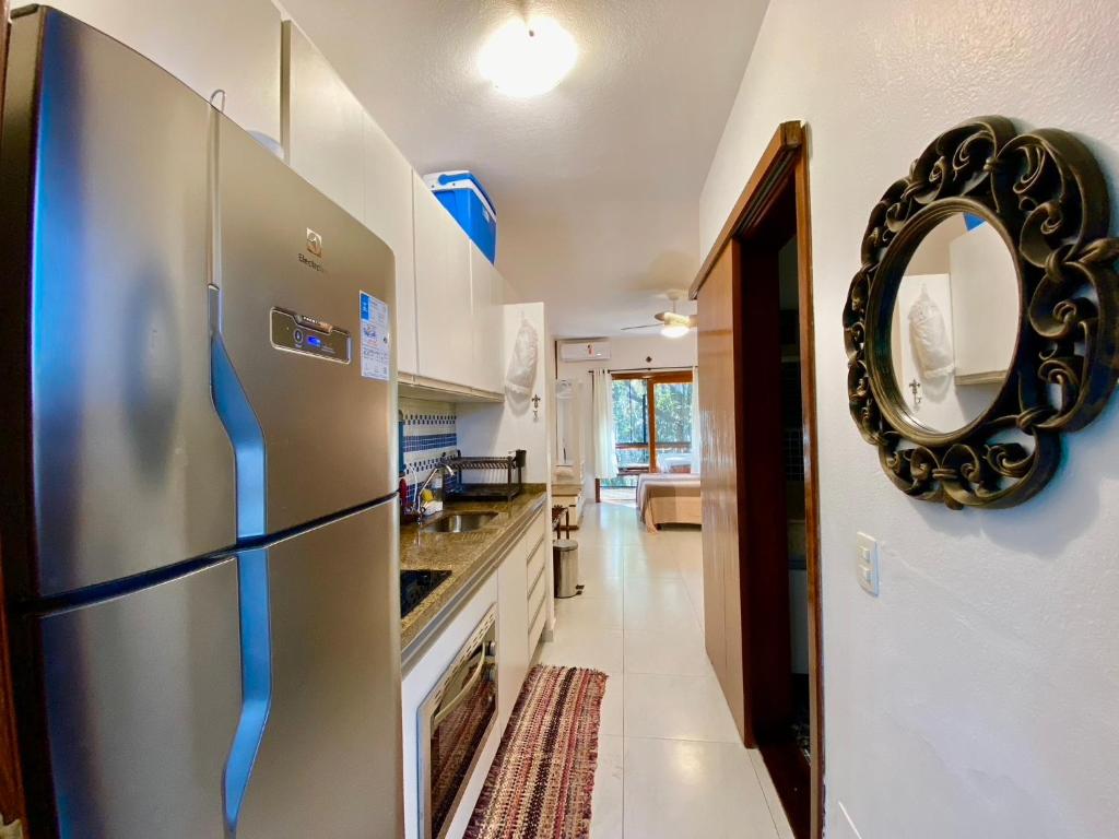 uma cozinha com um frigorífico de aço inoxidável e um espelho em Housing 31 - Cond. Mata Azul - frente á entrada 18 em São Sebastião