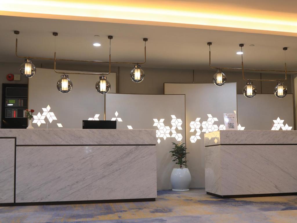 a lobby with a reception desk and lights at Skylight In-Terminal Hotel in Addis Ababa