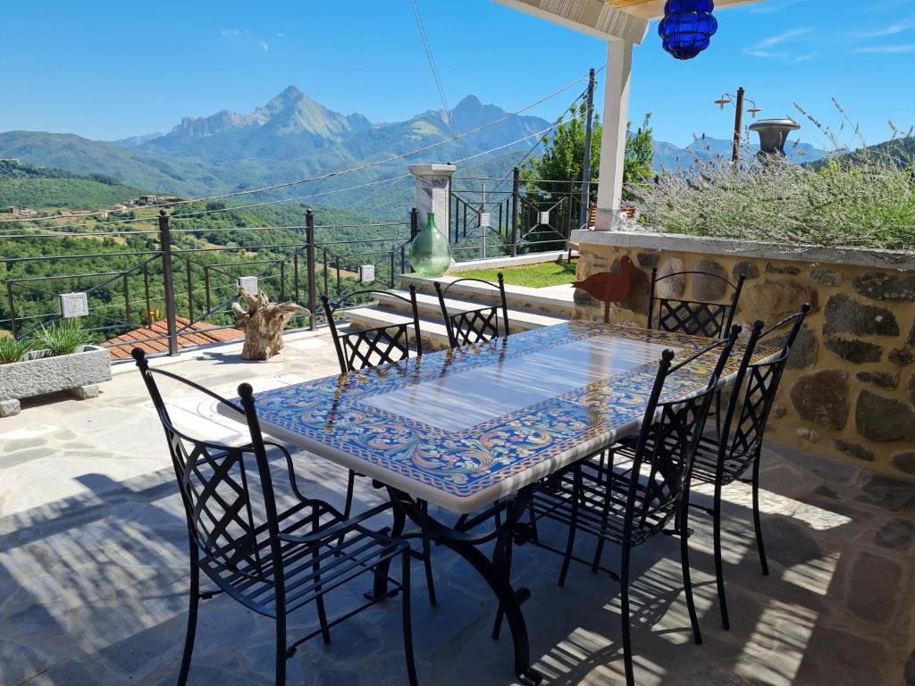 a table and chairs with a view of the mountains at DA ERCOLE casa vacanze di lusso con giardino, piscina e idromassaggio. in Vigneta