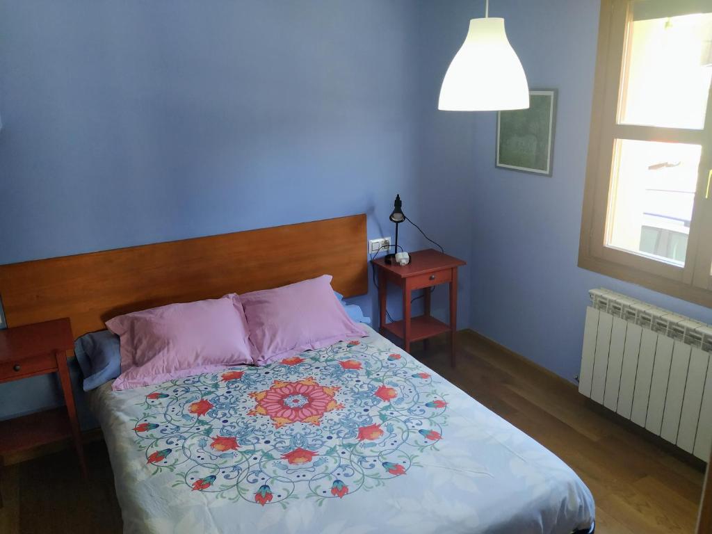 um quarto com uma cama com uma parede azul em APARTAMENTO ARCE I en el Valle de Benasque em Castejón de Sos
