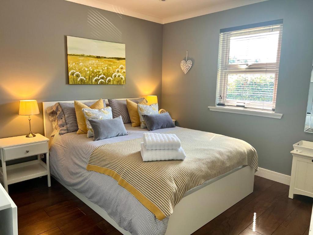 um quarto com uma cama com um quadro na parede em Holly Lodge - Luxury Two Kingsize bedrooms with private entrance - entire place em Oban