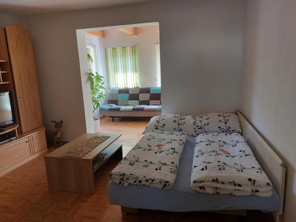 a bedroom with two beds and a living room at Grimmingapartment Maier in Stainach