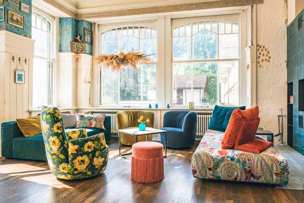 a living room with two chairs and a couch at Bellevue-Terminus - Urban Lifestyle Hotel in Engelberg