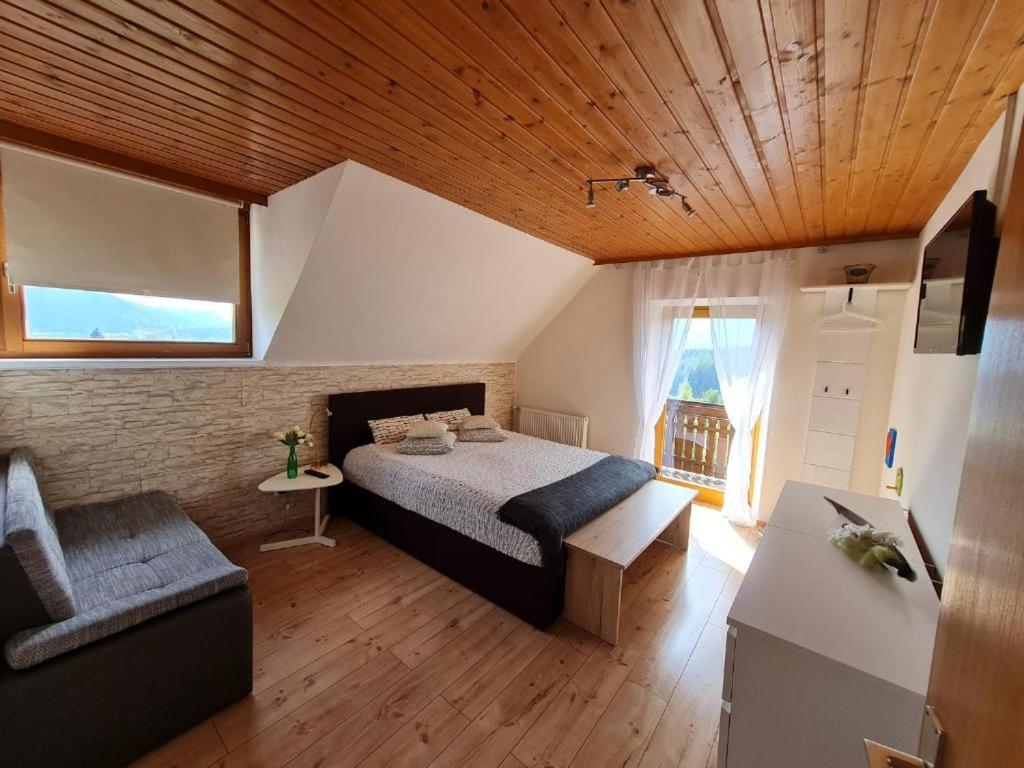 ein Schlafzimmer mit einem Bett, einem Stuhl und einem Fenster in der Unterkunft Ferienwohnungen MONFREDA Made for better days in Drobollach am Faakersee