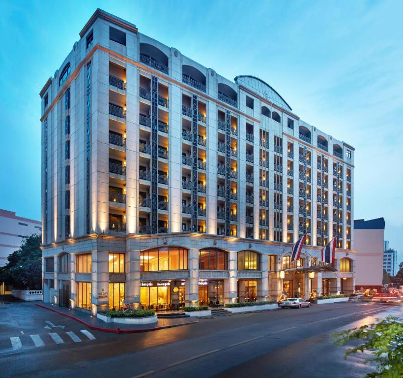 a large white building with windows on a street at The Davis Bangkok in Bangkok