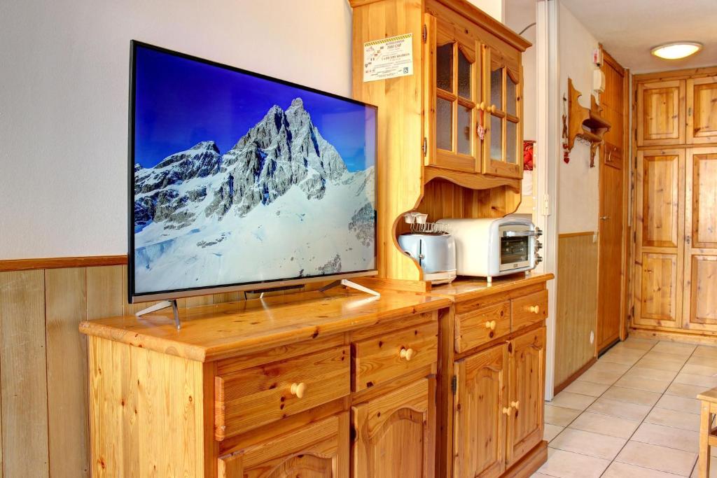 uma televisão de ecrã plano em cima de um armário de madeira em Marcolski Home - Schuss 1 em Breuil-Cervinia