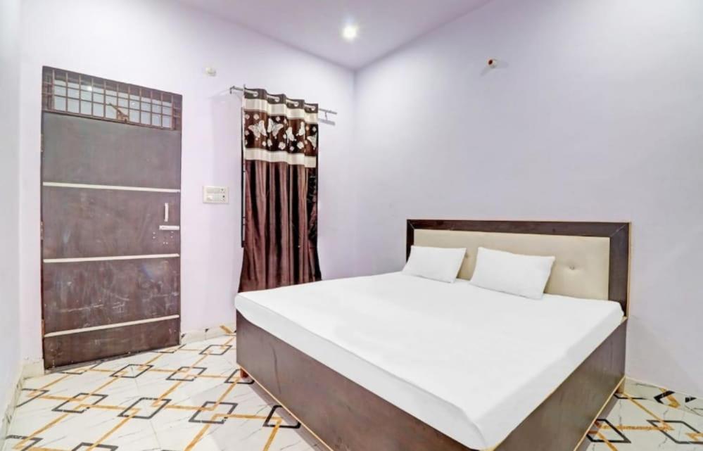 1 dormitorio con 1 cama grande y puerta en Hotel Krishna Palace & Restaurant By WB Inn, en Agra