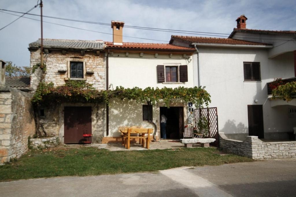 una casa blanca con una mesa de madera delante de ella en Holiday house with a parking space Celici, Central Istria - Sredisnja Istra - 7333 en Barban