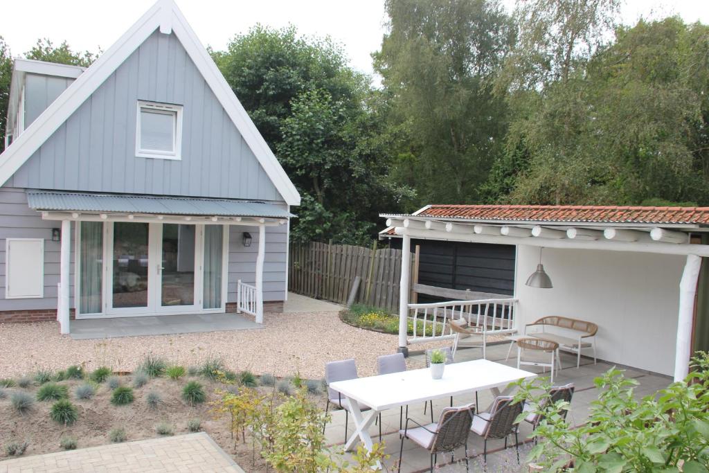 a backyard with a table and a shed at Lodge21Ouddorp in Ouddorp